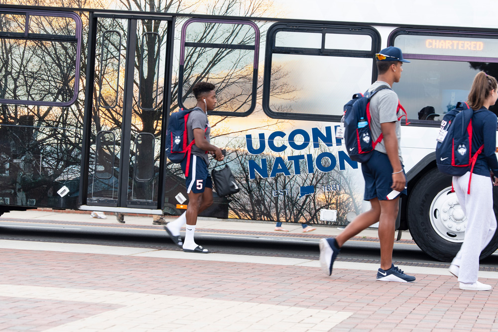 Mens soccer team waiting to board a shuttle bus along Fairfield Way