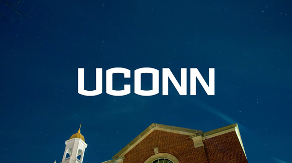 UConn white wordmark in the blue sky of a photo
