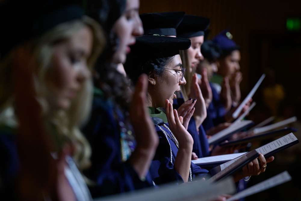 Oath given by students at commencement, focus on the center woman in the row